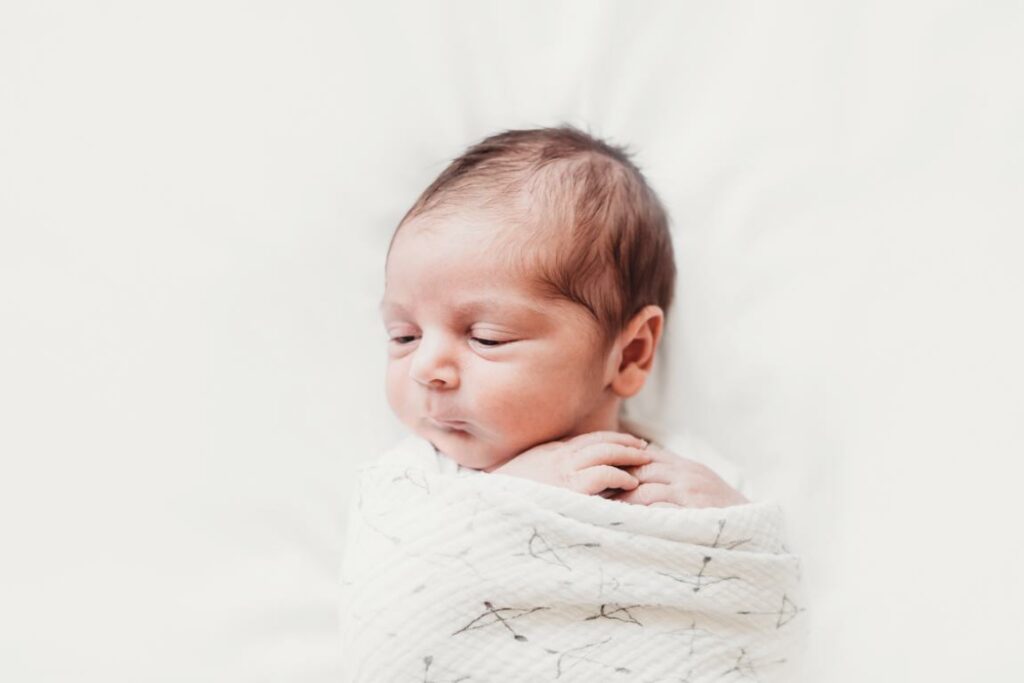 A newborn baby is wrapped and ready to sleep during his newborn photography session in Toronto.